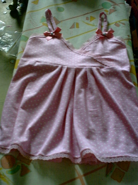 Top aus rosa weiß getupftem, dünnen Jersey in Größe 134, verziert mit Schleifen und Perlen, sowie einer Spitzenborde .
