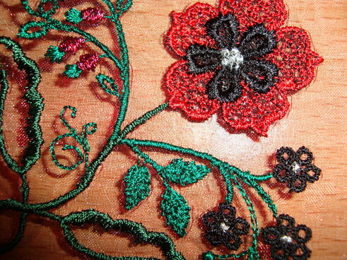Gestickte Blume auf Organza (Detailansicht)
Der Stoff ist eigentlich ungeeignet zum besticken aber mit einem Trick gehts doch:
Stoff zwischen zwei Lagen "Wash-away" Vlies packen und einspannen-losticken und danach auswaschen-fertig