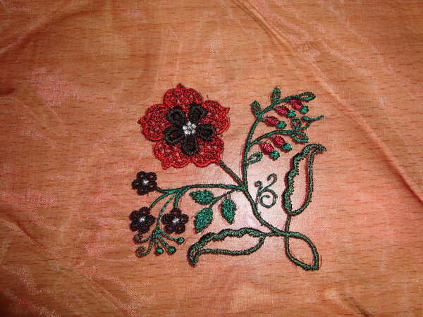 Gestickte Blume auf Organza
Der Stoff ist eigentlich ungeeignet zum besticken aber mit einem Trick gehts doch:
Stoff zwischen zwei Lagen "Wash-away" Vlies packen und einspannen-losticken und danach auswaschen-fertig