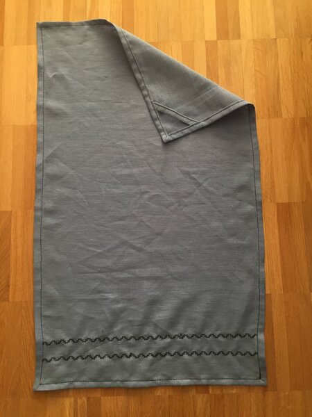 Ein reinleinen Geschirrhandtuch.

Nach der ersten Kochwäsche sind die Wellen weg gewesen.
Nicht vorher waschen kann auch mal sinnvoll sein ;-)