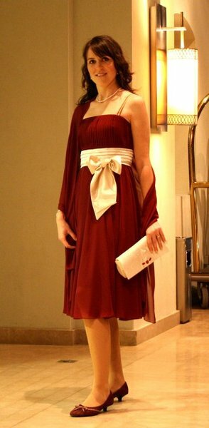 Eine Eigenkreation bestehend aus aubergine-farbenem Abendkleid mit weiß-goldener Schleife, einem passenden Schultertuch und einer Clutch aus dem Satin, aus dem die Schleife ist.