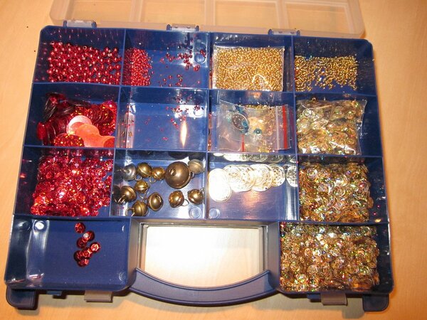 Perlen und Pailletten in gold und rot. Die Pailletten sind holo-gold und holo-rote Schüsselpailletten. Die roten Perlen sind teilweise aus Kunststoff, einige aus Glas. Die goldenen sind aus Glas. Und Glöckchen habe ich auch noch ;o)