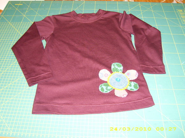 Shirt 110
Mit applizierter plastischer Blume, hinten mit besticktem Namenszug