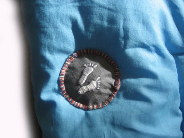 Button mit Babyfüßen auf der Rückseite der Krabbeldecke