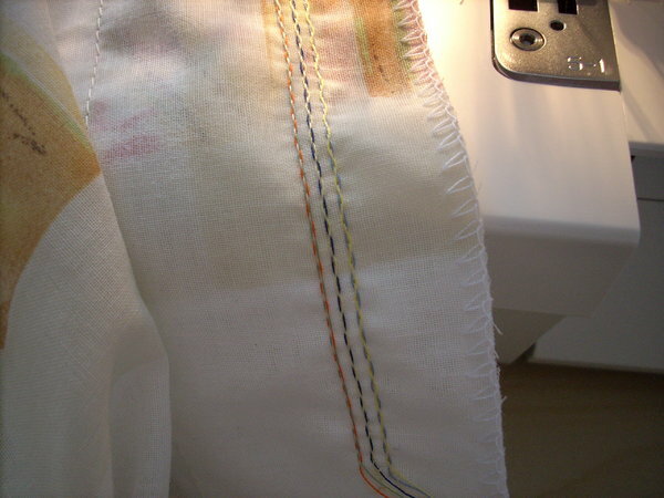 Fertig genähter Stich. 3x Grundfäden für die Nadeln, 1 Faden für den Kettenstichgreifer, 6 x Deko-Garn der um die Nadelfäden verschlungen wird.